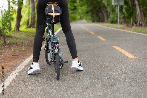 Young woman cyclist riding bike on road in park. healthy lifestyle concept