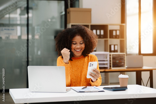 African business woman are delighted and happy with the work they do on their tablet, laptop and taking notes at the office.