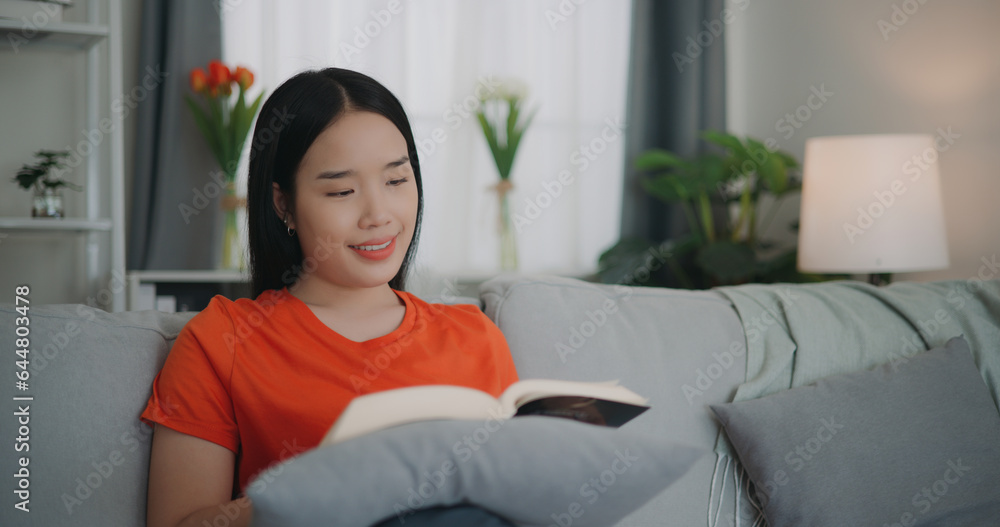 Asian woman reading a book while sitting on the sofa Asian woman reading a book while sitting on the sofa