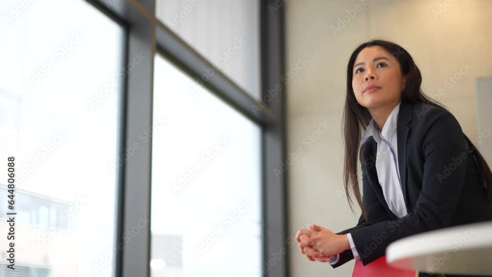 Contemplative woman gazing out window while leaning on chair Contemplative woman gazing out window while leaning on chair