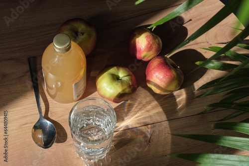Картината върху платно woman carefully pours apple cider vinegar into a spoon, adding it to a glass of water to create a healthy, invigorating drink