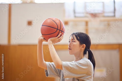 体育館でバスケットボールの練習をするスポーツウェアを着た日本人女性 © west_photo