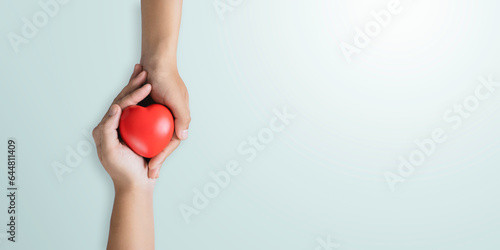 Obraz na płótnie top view of hands holding red heart in concept healthcare, wellbeing, organ donation, and insurance life