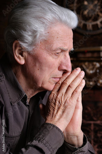close-up portrait of a sad elderly man on a black background