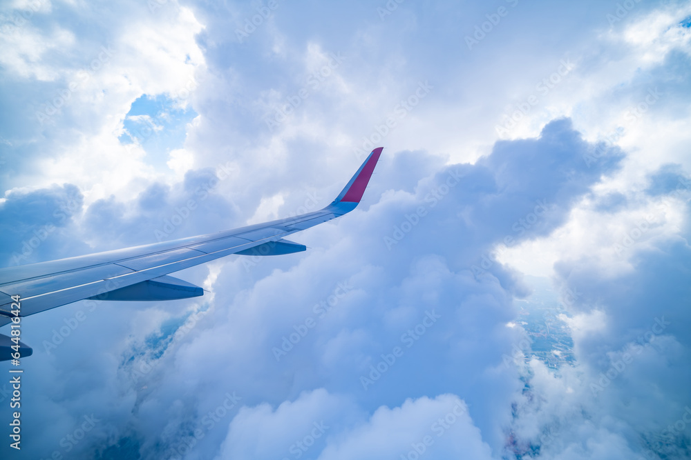 Clear blue sky with fluffy ornamental cumulus clouds, panoramic view from an airplane, wing close-up. Travel, tourism, vacations, turbulence Clear blue sky with fluffy ornamental cumulus clouds, panoramic view from an airplane, wing close-up. Travel, tourism, vacations, turbulence