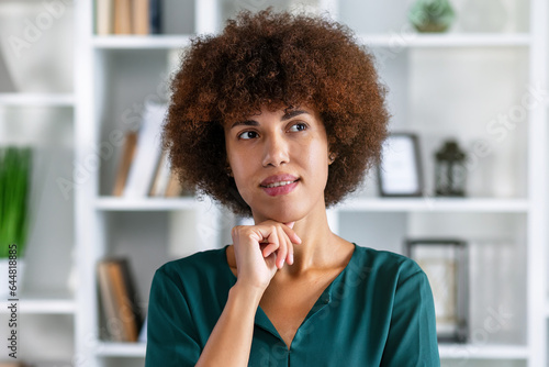 Serious young African business woman head shot portrait. Thoughtful Black businesswoman looking away with pensive face, dreaming, thinking over project tasks, problem solving