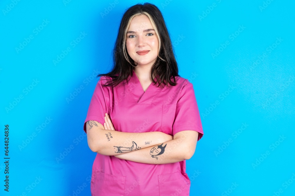Dreamy rest relaxed Young caucasian doctor woman wearing pink medical uniform crossing arms, Dreamy rest relaxed Young caucasian doctor woman wearing pink medical uniform crossing arms,