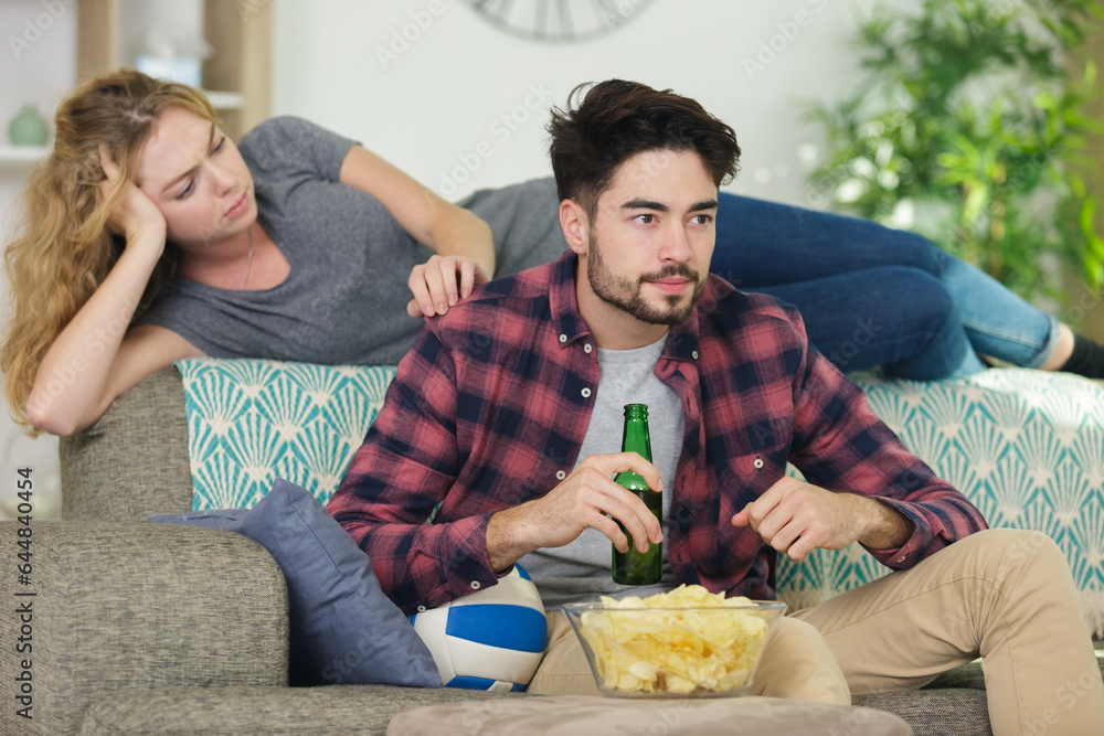 attractive couple sitting on the floor with beer and popcorn