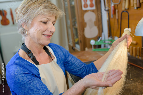 Fotografie Woman examining fibres in instrument workshop