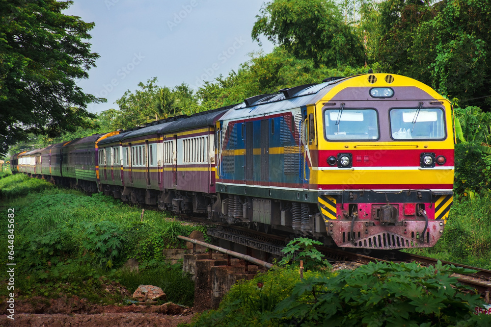 Passenger train by diesel locomotive passes the steel bridge.