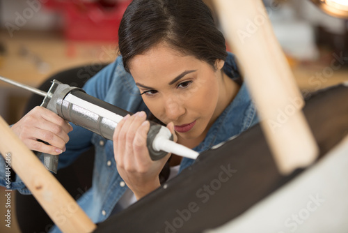 woman using silicone for gluing a chair