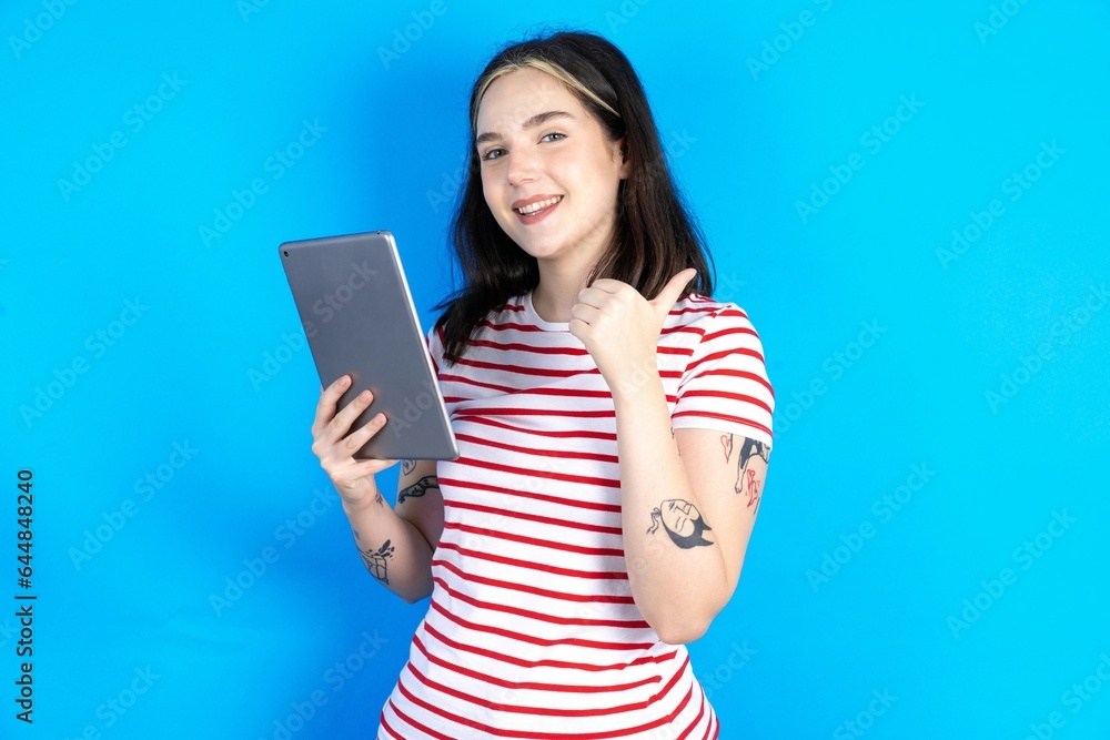 beautiful young woman wearing striped T-shirt pointing empty space modern device beautiful young woman wearing striped T-shirt pointing empty space modern device
