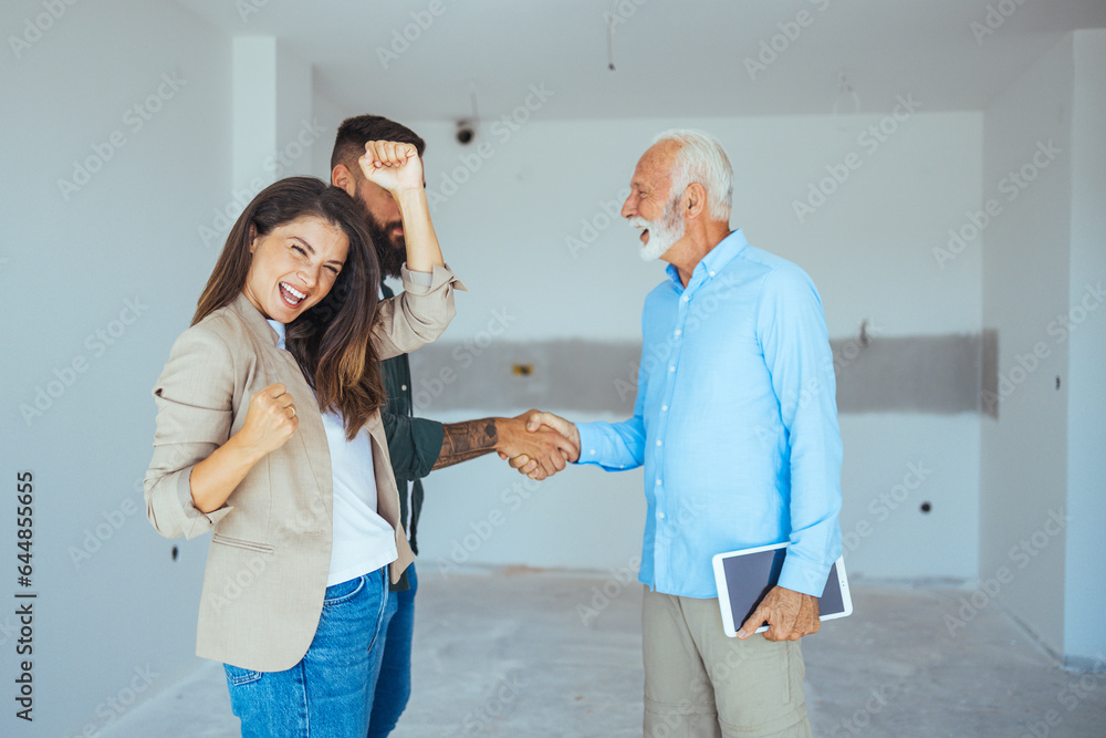Obraz premium Happy couple buying a new home and handshaking with their real estate agent. Estate Agent Greeting Couple During Visit To New Home. Couple house property agent home real estate 