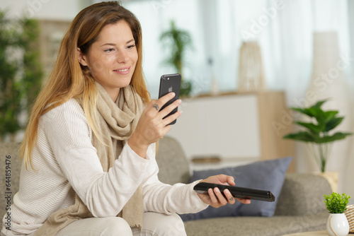 happy woman using mobile phone on sofa