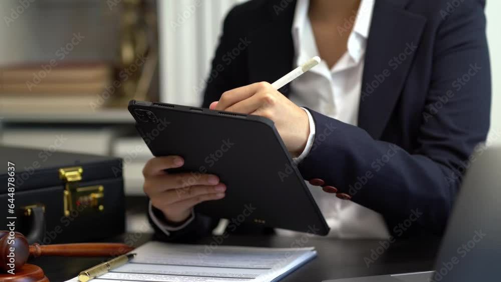 Justice and law concept.Male judge in a courtroom the gavel, working with digital tablet computer Justice and law concept.Male judge in a courtroom the gavel, working with digital tablet computer