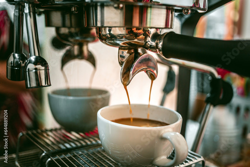 Close-up of espresso pouring from the coffee machine into a coffee cup. Professional coffee brewing