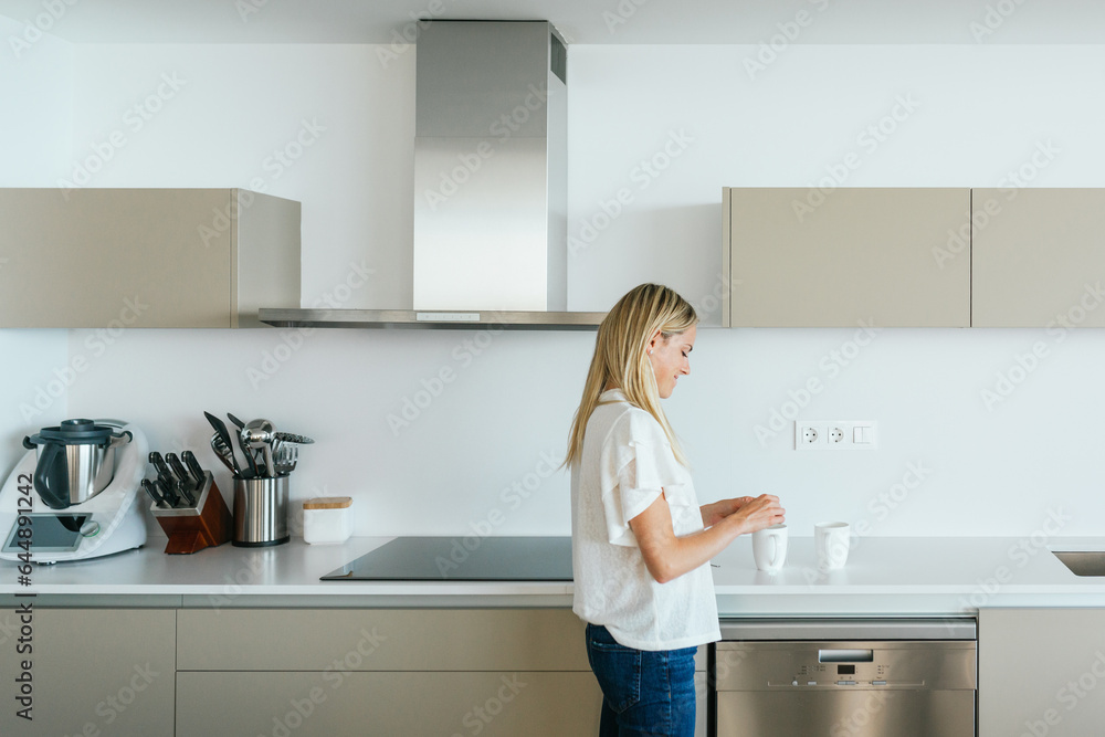 Woman making tea in kitchen Woman making tea in kitchen