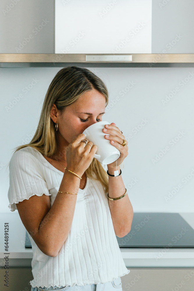 Woman drinking coffee in kitchen Woman drinking coffee in kitchen