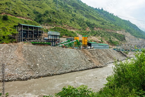 Heavy machinery at a Hydro Electric Power Project on River Satluj , Himachal Pradesh, causing river bank erosion in India. River devastation scene. photo