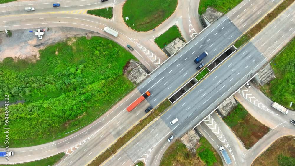 Aerial view of a dogbone interchange: A highway interchange resembling a bone shape, with loops connecting roads, seen from above, captured by a drone.
Aerial view of a dogbone interchange: A highway interchange resembling a bone shape, with loops connecting roads, seen from above, captured by a drone.