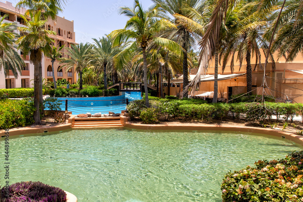 Swimming pool with clear water surrounded by palm trees in one of the best resorts