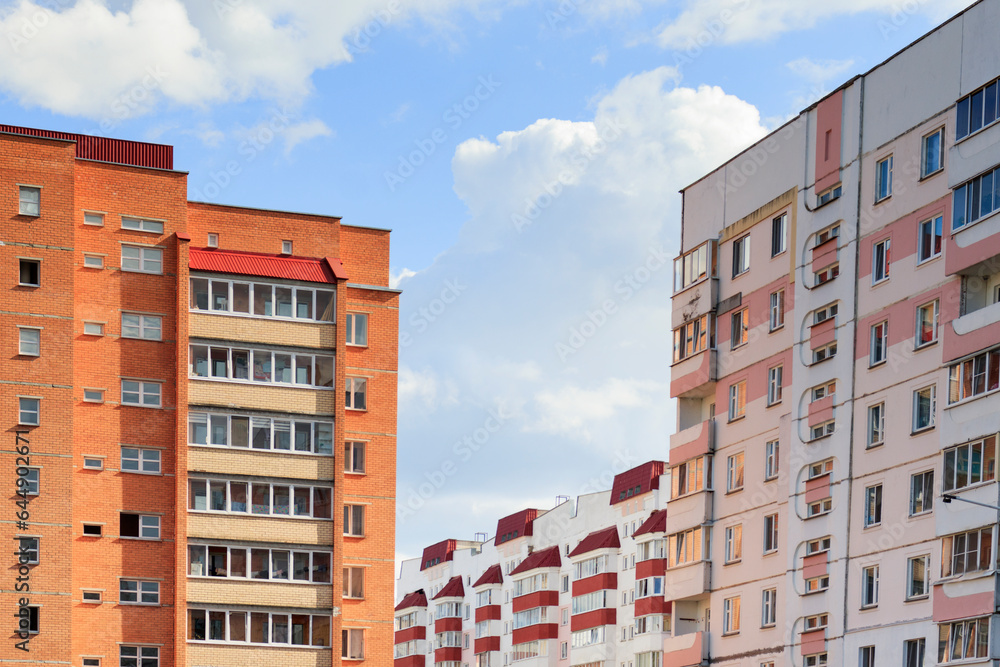 Multi-storey buildings are close to each other. White and red houses against a sky. Housing concept