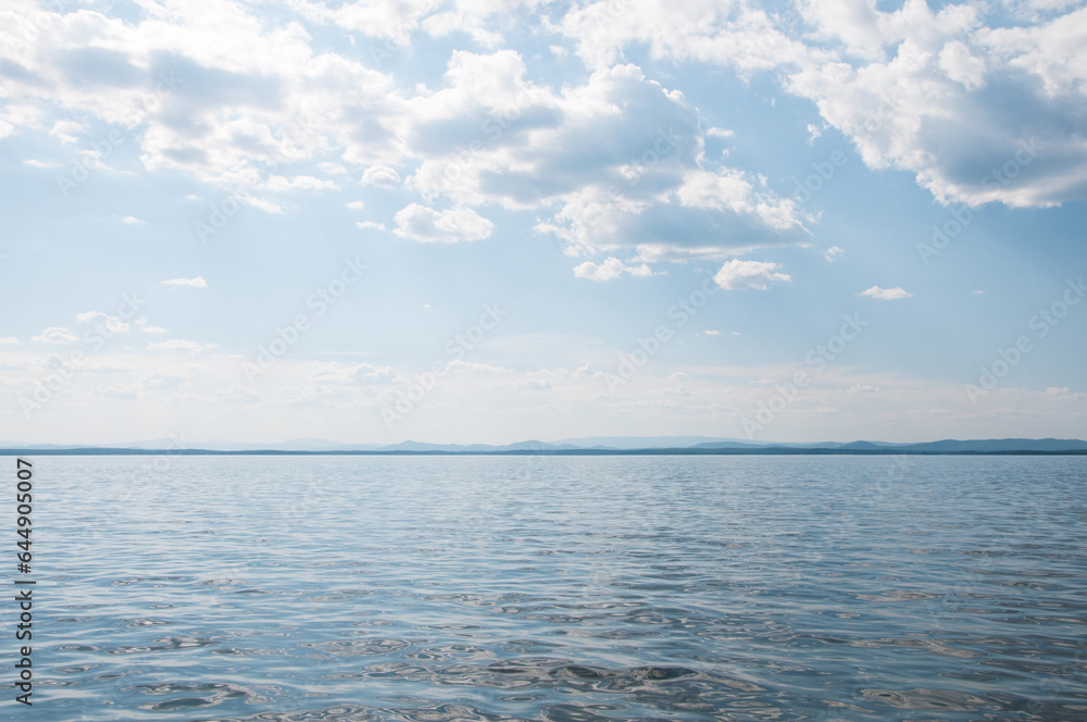 Obraz premium Seascape view of lake Uvildy in summer with cloudy blue sky above it, South Ural, Russian Federation