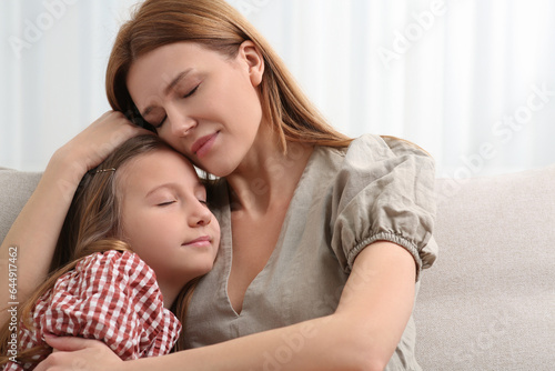 Mother and her cute daughter on sofa at home