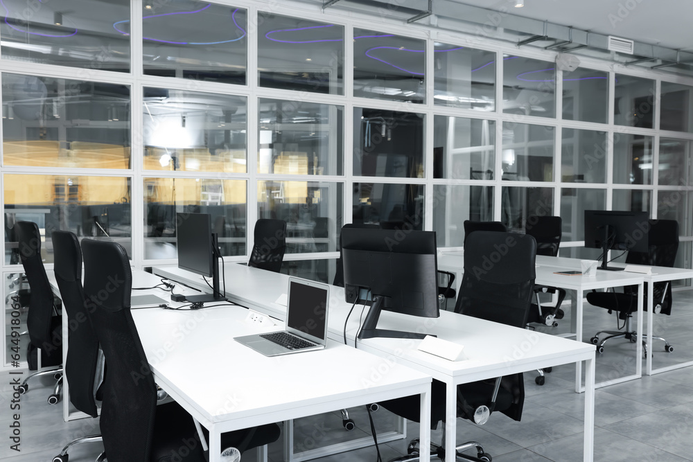 Stylish interior of open plan office. Workspace with computers, tables and chairs Stylish interior of open plan office. Workspace with computers, tables and chairs