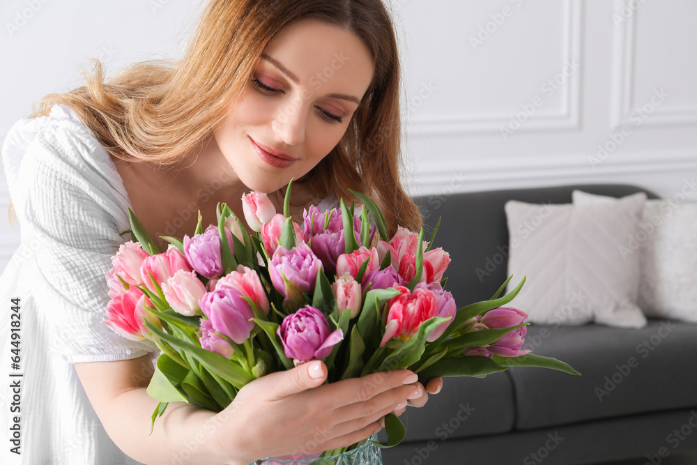 Young woman with bouquet of beautiful tulips indoors Young woman with bouquet of beautiful tulips indoors