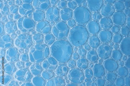 Macro photo of bubbles on light blue background, top view