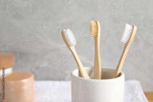 Holder with bamboo toothbrushes in bathroom  closeup. Space for text