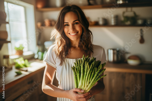 Beauty portrait of smiling woman holding asparagus in hands. Healthy food concept