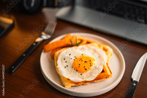 Breakfast waffles, fried eggs and sausage photo