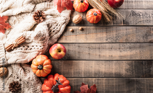 Autumn and thanksgiving decoration concept made from autumn leaves and pumpkin on dark wooden background. Flat lay, top view with copy space.