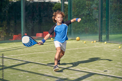 Boy playing padel on court