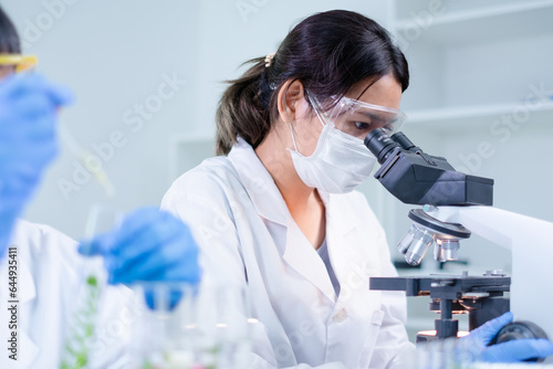 Female scientist use microscope to explore, research or analyze a substance. Biology, microbiology, medical and biochemistry laboratory. Serious scientist focus on organism experiment and studying.