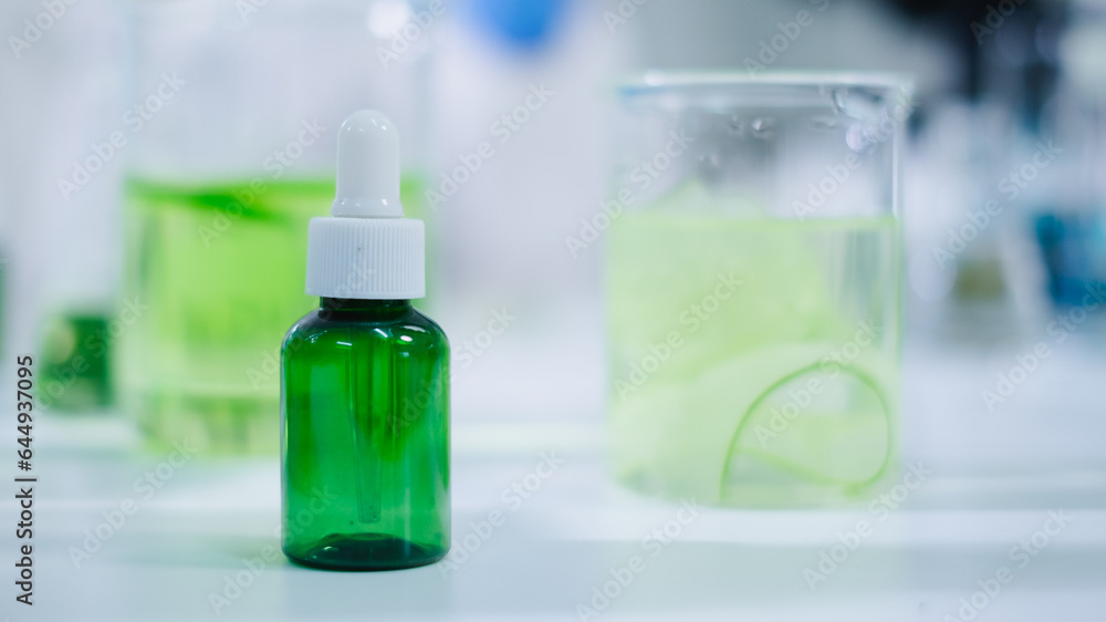 Close up of cosmetic, skincare and treatment package or product laboratory with equipment and cucumber in glassware, test tube or beaker. Concept of Serum, gel or cream essential experiment advertise. Close up of cosmetic, skincare and treatment package or product laboratory with equipment and cucumber in glassware, test tube or beaker. Concept of Serum, gel or cream essential experiment advertise.