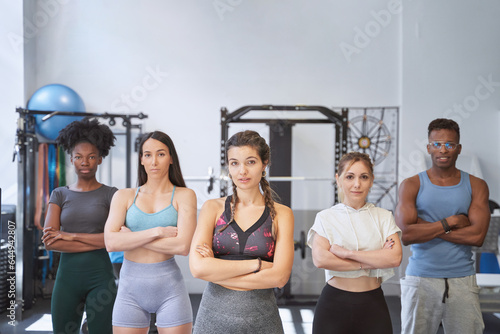 Confident female trainer standing in front of team at the gym. Sport concept.