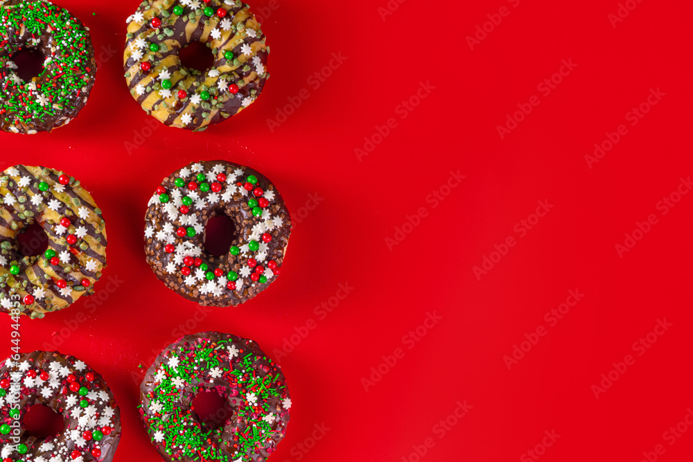 Bright festive decorated Christmas and New Year donuts set, with colorful red, green white snowflake sugar sprinkles. Sweet seasonal Christmas dessert