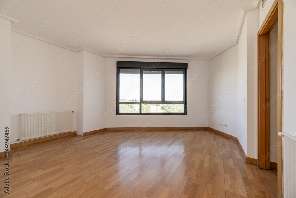 An empty living room with cheap radiators An empty living room with cheap radiators