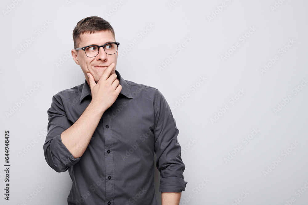 Portrait of clever man in shirt touching chin thinks doubts chooses isolated on white studio background with copy space Portrait of clever man in shirt touching chin thinks doubts chooses isolated on white studio background with copy space