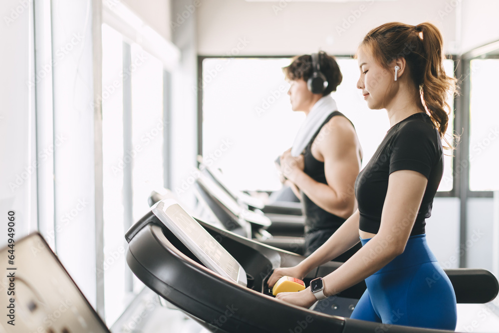 Young people running on a treadmill in health club. Sport fitness healthcare and healthy lifestyle concept. Young people running on a treadmill in health club. Sport fitness healthcare and healthy lifestyle concept.