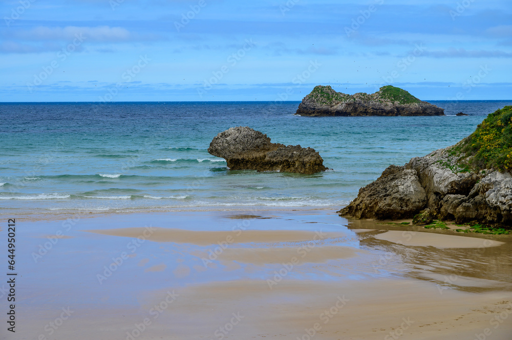 View on Playa de Palombina Las Camaras in Celorio, Green coast of Asturias, North Spain with sandy beaches, cliffs, hidden caves, green fields and mountains.