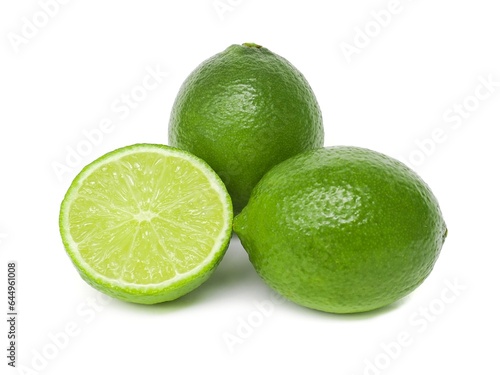 Fresh green lemons and lime leaves placed on a white background.