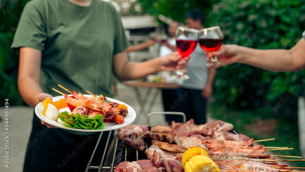 Home Garden BBQ Party, Wine Glasses Clink in Family Toast, enjoying harvest time together outside at front of house, grandfather and grandfather asian people, man and woman