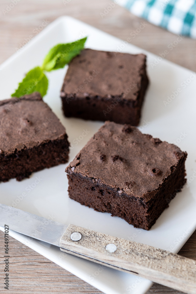 Chocolate brownie portions on wooden background