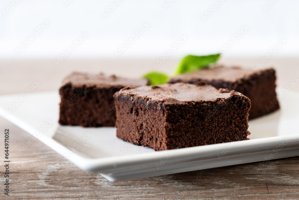 Chocolate brownie portions on wooden background