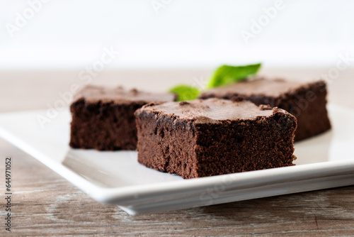 Chocolate brownie portions on wooden background