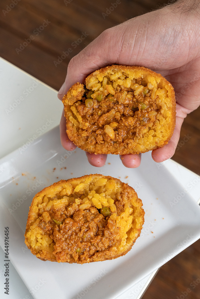 Hands showing a fried rice ball inside. Sicilian Street Food Hands showing a fried rice ball inside. Sicilian Street Food